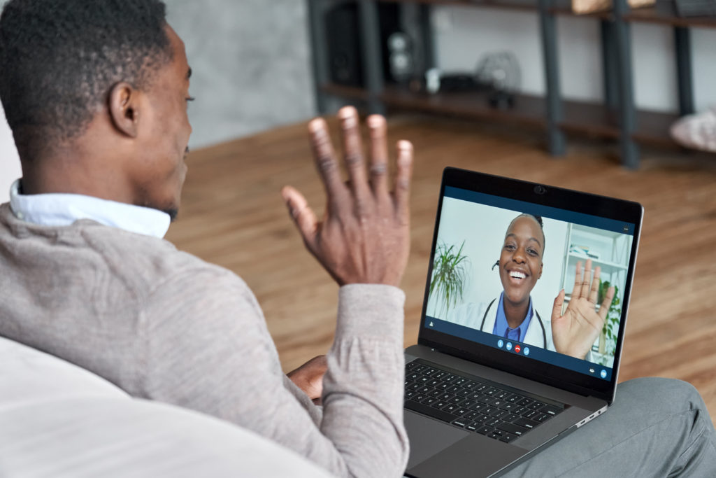 Image of male patient on conference video call with female online doctor