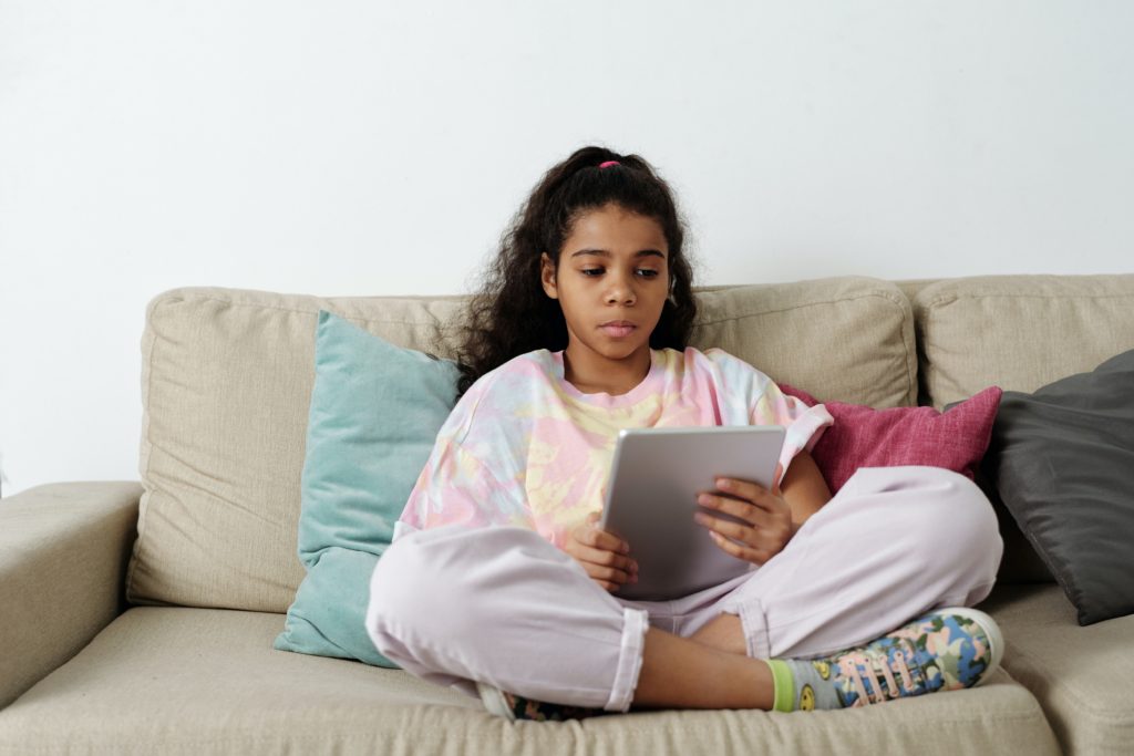 image of a young girl sitting on a couch and reading