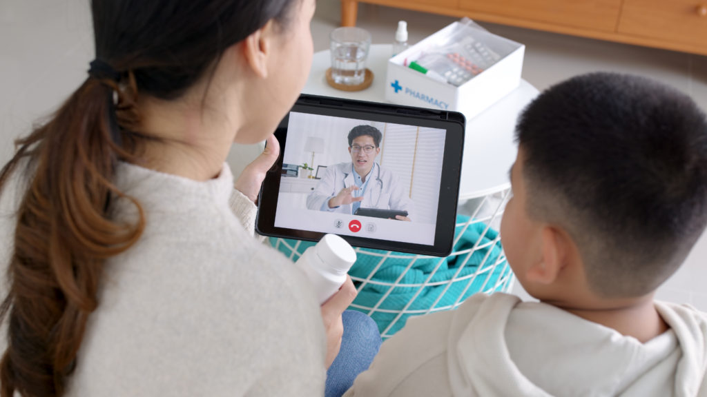 Over shoulder view of young asia parents and son talk to doctor