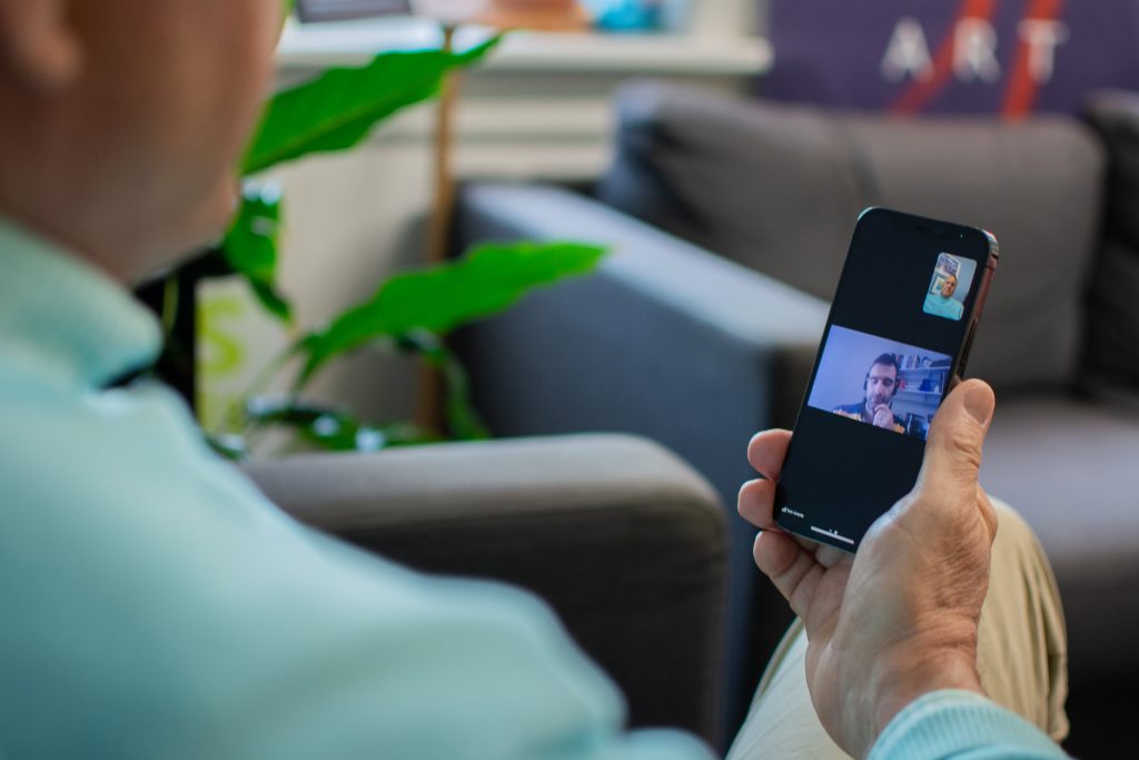 Virtual therapy session takes place via cell phone for older adult.